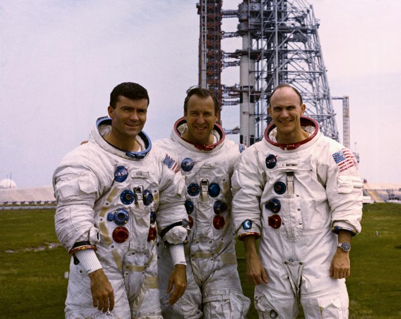 Apollo 13 astronauts Fred Haise, Jim Lovell, and Ken Mattingly in spacesuits.