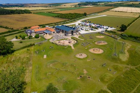 Aerial view of Williams Den camping site in Yorkshire, showing buildings, parking lot, and playground.