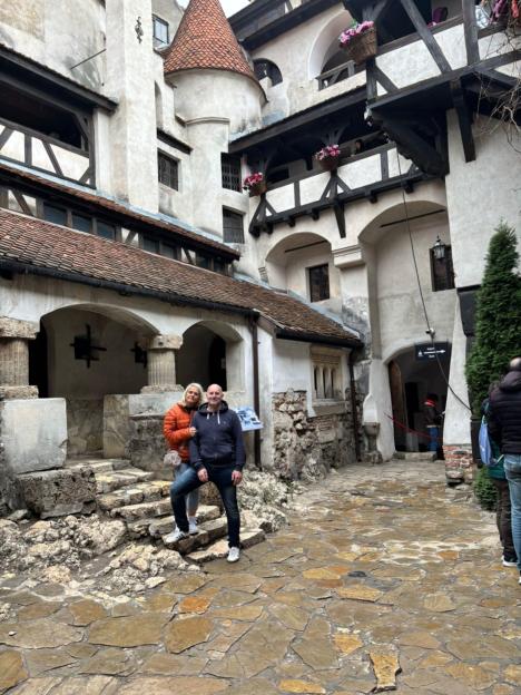 Couple standing in a castle courtyard.