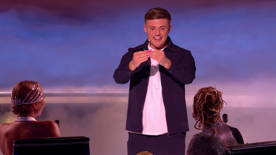 Magician performing card trick for judges.