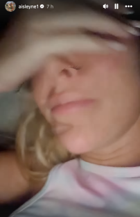 Screenshot of a woman covering her eyes with her hands.