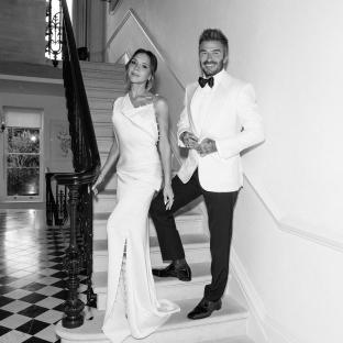 Black and white photo of David and Victoria Beckham on a staircase.