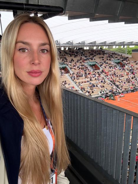 A blonde woman at a tennis stadium.
