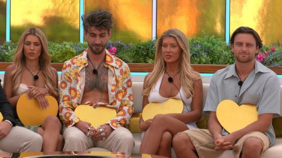 Four Love Island contestants holding golden hearts.