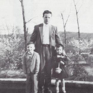 Black and white photo of Bruce Springsteen as a child with his father and sister.