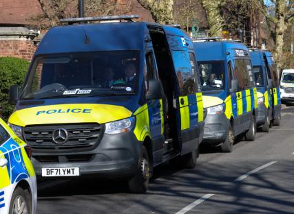 Police vans parked on a street.