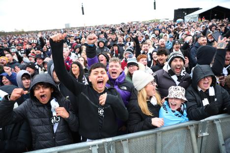 Excited Newcastle United fans at a victory parade.