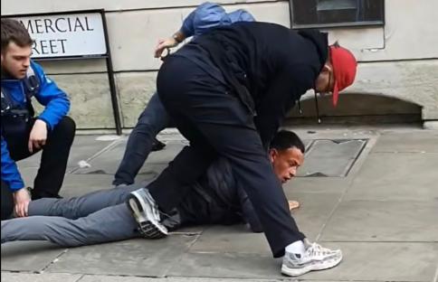 Police officers arresting a man on the ground.