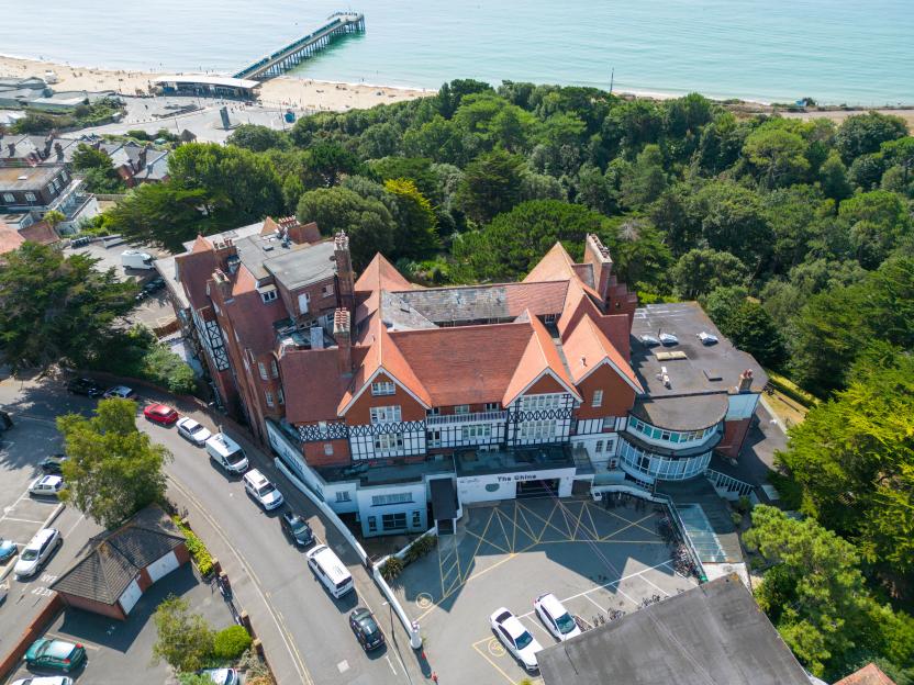 Aerial view of The Chine hotel in Bournemouth, UK, surrounded by cars and bikes.