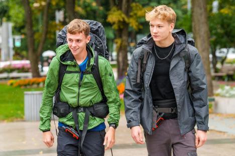 Two young men with backpacks walking outdoors.