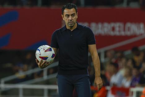 Barcelona's head coach Xavi Hernandez holds the ball during a Spanish La Liga soccer match between Barcelona and Sevilla, at the Olympic Stadium of Montjuic in Barcelona, Spain, Friday, Sept. 29, 2023. (AP Photo/Joan Monfort)
