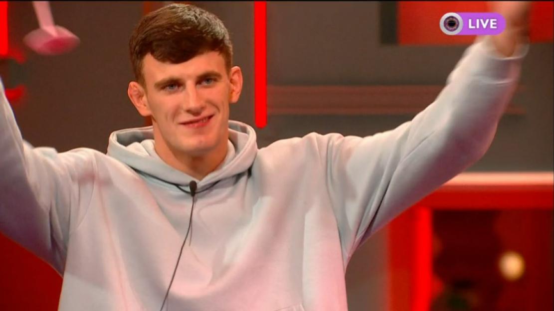 Cameron B, a young man with short dark hair and a light grey hoodie, smiles with arms raised, a "LIVE" icon visible in the top right.