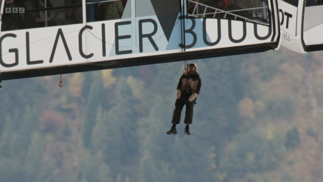 Person dangling from a Glacier 3000 cable car.