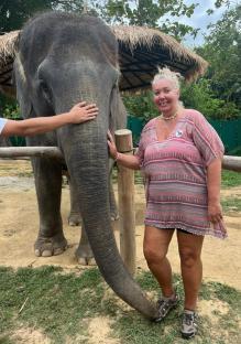 Woman standing next to an elephant.