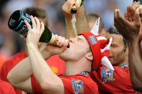 Wayne Rooney celebrates after a Manchester United victory by drinking champagne.