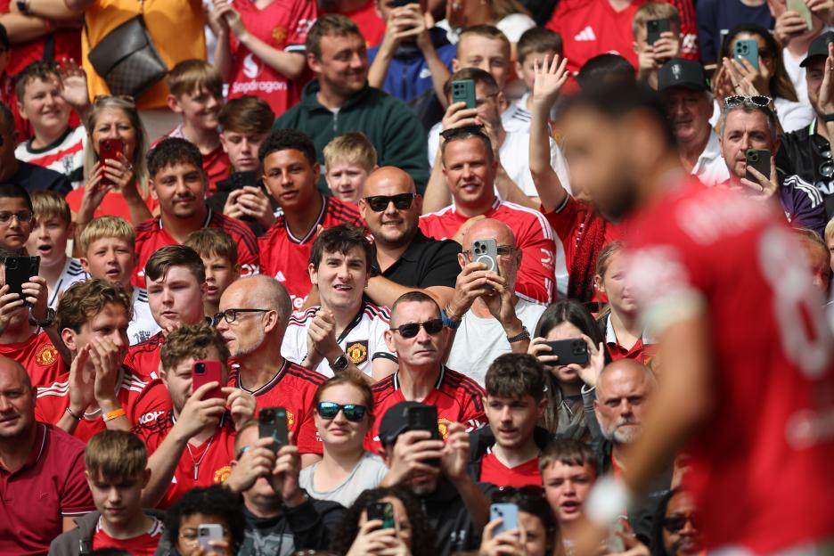 Manchester United fans using phones to film Bruno Fernandes.