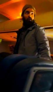 Man on airplane attempting to open emergency exit door.