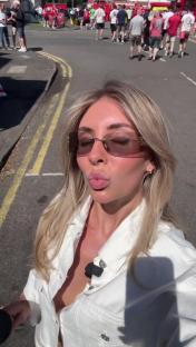 Woman blowing a kiss at a football stadium.