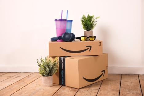 Amazon Prime boxes with headphones, sunglasses, and drinks on top.