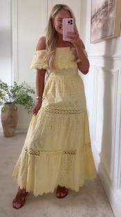 Woman in a yellow eyelet maxi dress.