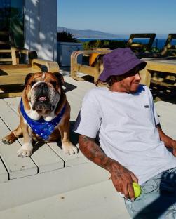 Lewis Hamilton and his bulldog Roscoe on a patio.