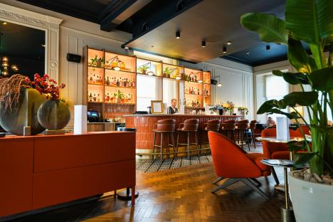 Interior view of a bar with a bartender and patrons.