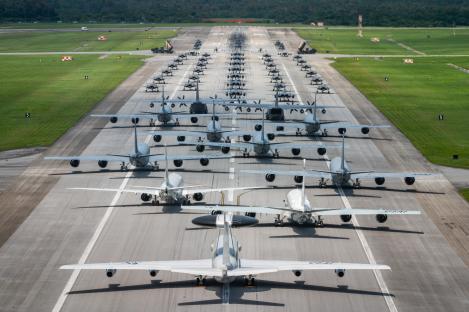 Aerial view of military aircraft lined up on a runway for an elephant walk exercise.