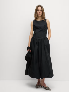 Model wearing a black midi dress and shoes.