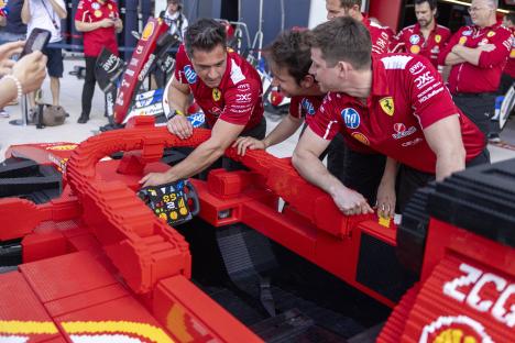 Ferrari mechanics examining a large Lego model of a Formula 1 car.