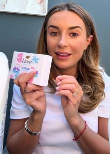 Woman holding Dove Summer Resort body wash.