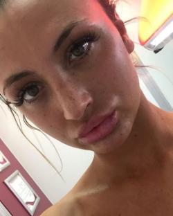 Close-up selfie of a woman with freckles.