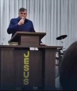 Pastor speaking at a pulpit with