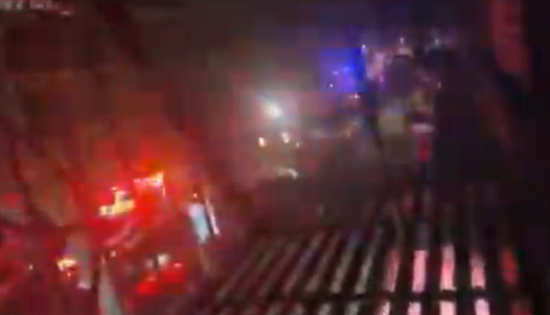 Blurry image of a dark scene with red and blue lights.