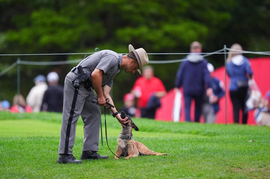 Police officer with a dog at the Bethpage Black Course, Farmingdale, New York.