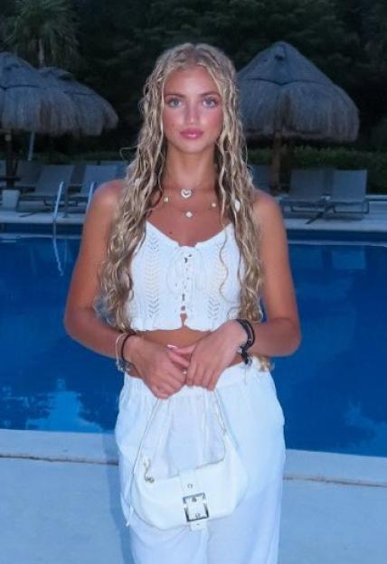 Princess Andre in a white outfit by the pool.