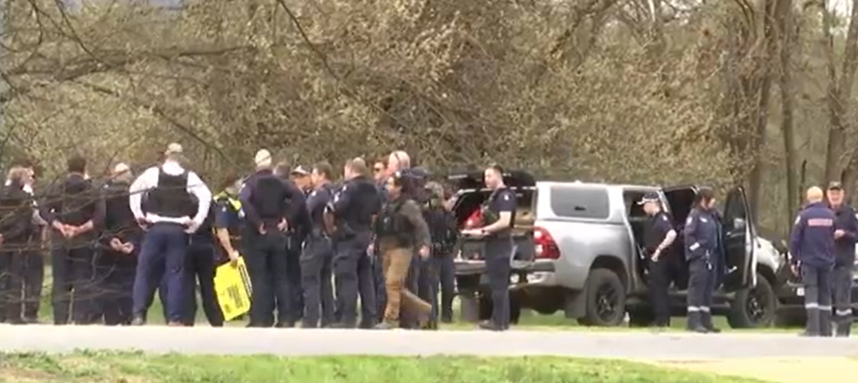 Police officers gathered near a vehicle.