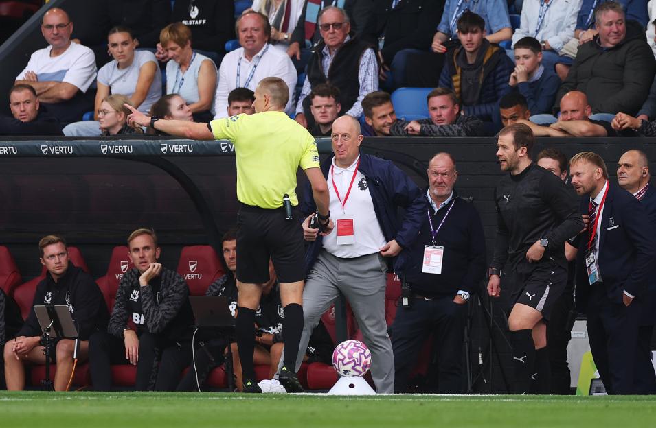 Referee speaking with Premier League officials.