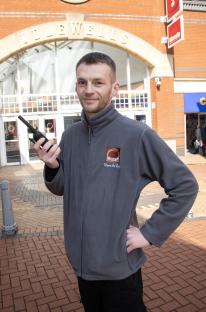 A security worker at Idlewells Shopping Centre holding a radio.