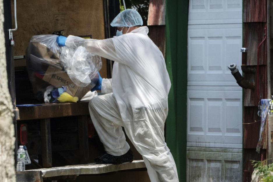 A crime laboratory officer places a bag of items into the back of a truck as law enforcement searches the home of Rex Heuermann, Saturday, July 15, 2023, in Massapequa Park, N.Y. Heuermann, a Long Island architect, was charged Friday, July 14, with murder in the deaths of three of the 11 victims in a long-unsolved string of killings known as the Gilgo Beach murders. (AP Photo/Jeenah Moon)