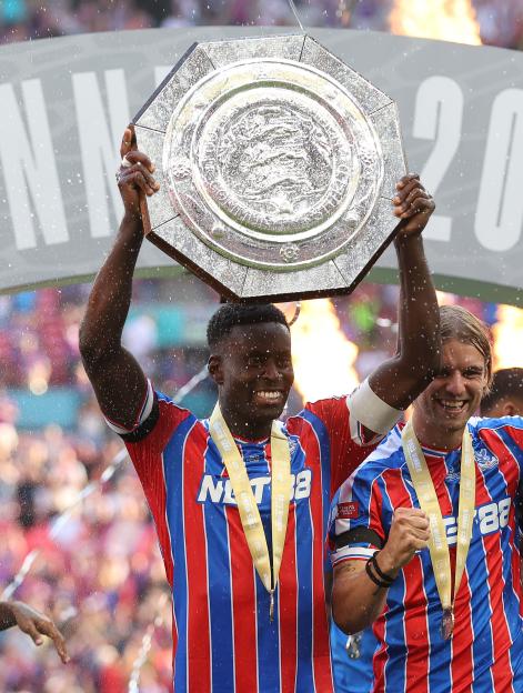 Marc Guehi of Crystal Palace holding the FA Community Shield trophy aloft.