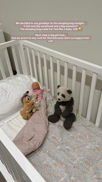 Baby's cot with stuffed animals and a doll.