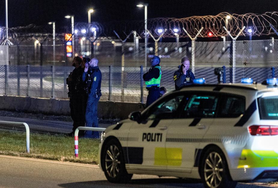 Police officers stand guard at night at Copenhagen Airport.