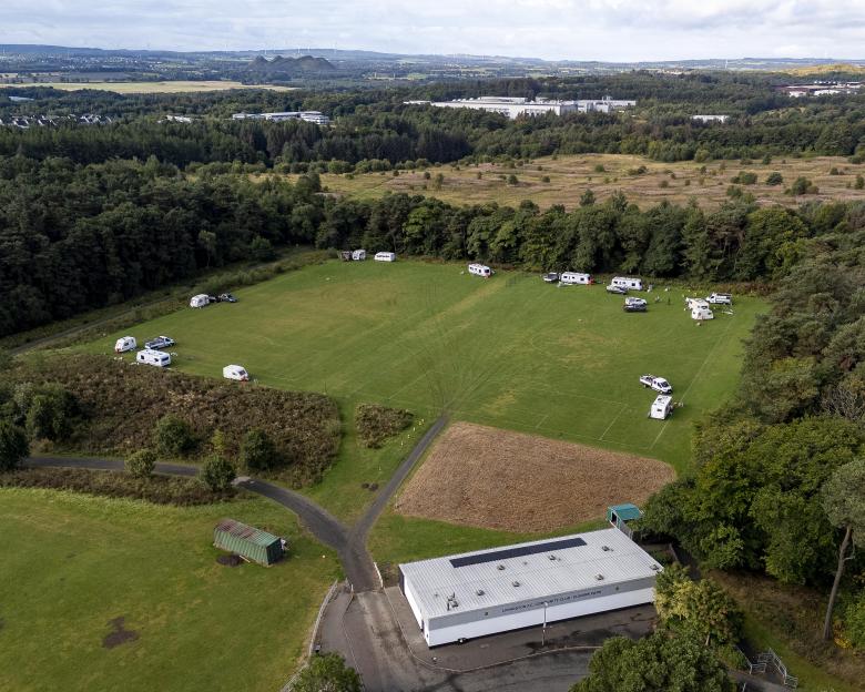 Aerial view of caravans parked on a football pitch.