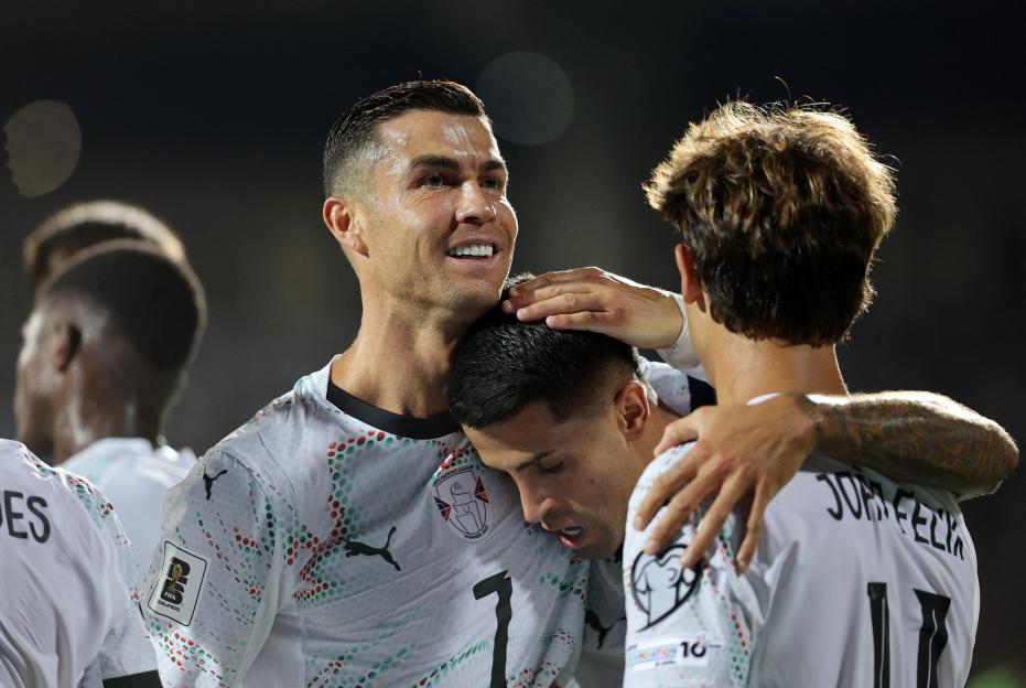 Cristiano Ronaldo, Joao Cancelo, and Joao Felix celebrating a goal.