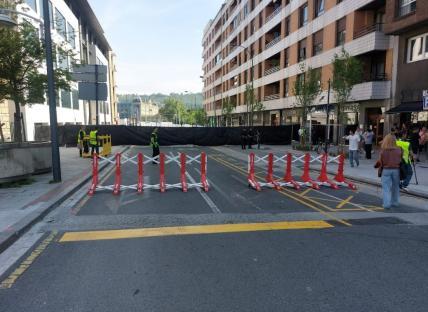 Road blocked with barriers and police officers.