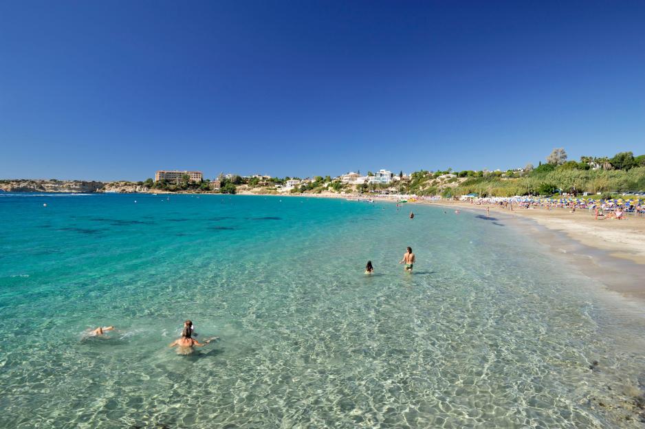 Vacationers enjoying the water at Coral Bay beach in Paphos District, Cyprus.