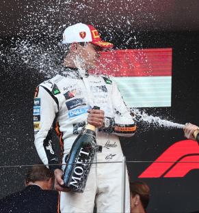 Lando Norris and Oscar Piastri celebrating a Formula 1 win with champagne.