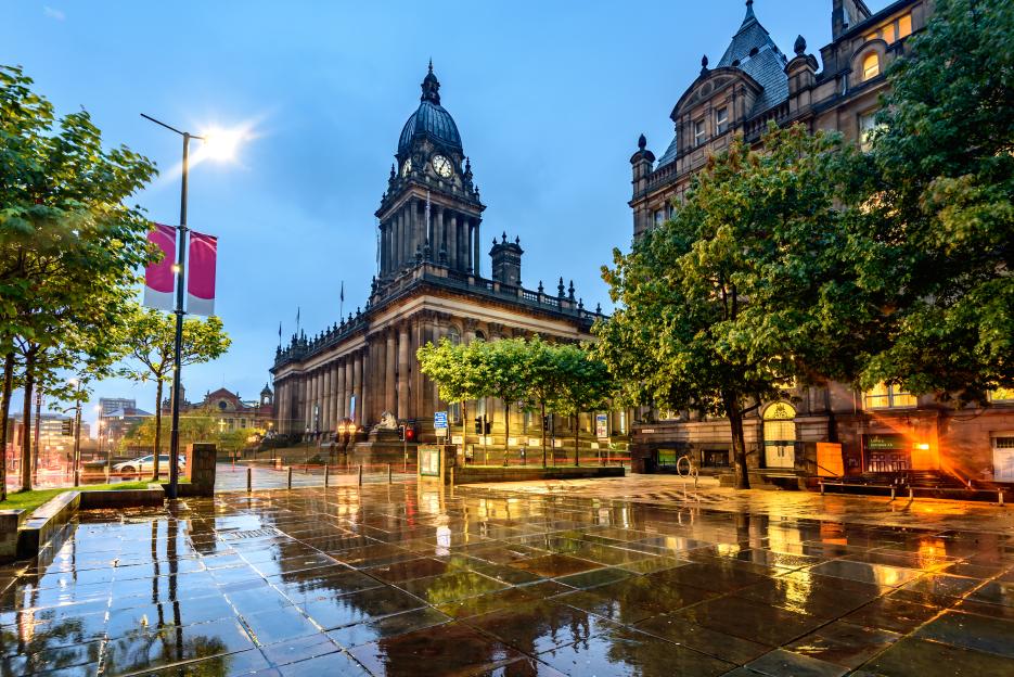 Leeds Town Hall at night with a street lamp on the left.