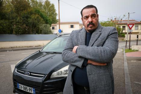 Private hire driver Nasim Mimun standing by his car.