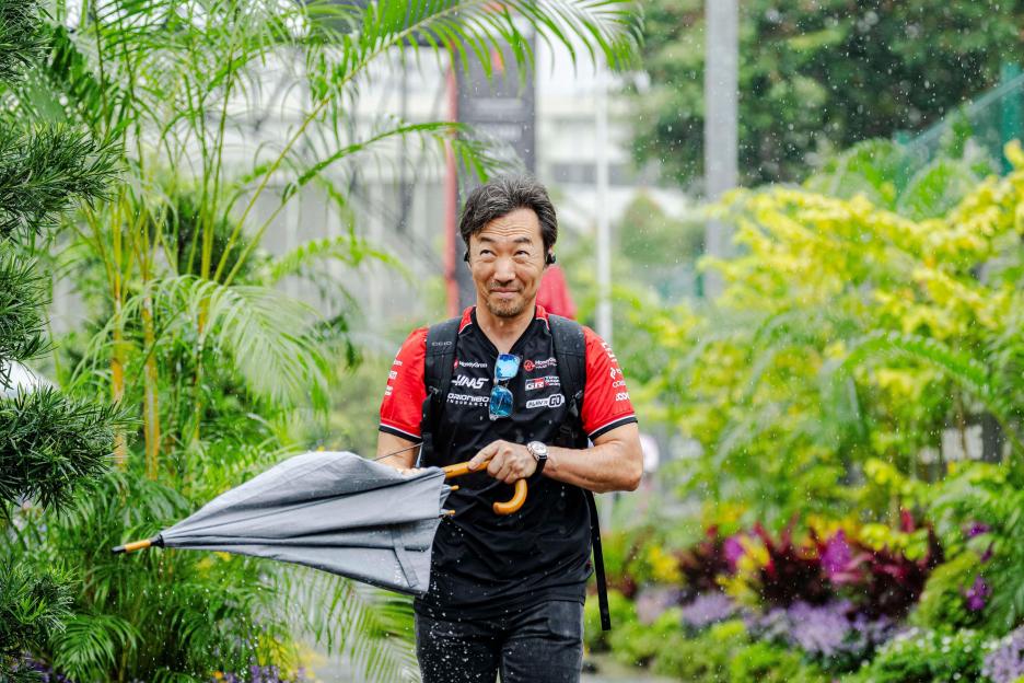 Ayao Komatsu holding a closed umbrella while walking in the rain during Media Day at the Formula 1 Singapore Airlines Singapore Grand Prix 2025.